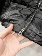 Gucci puffer jacket front zipper pull on dark GG-patterned fabric