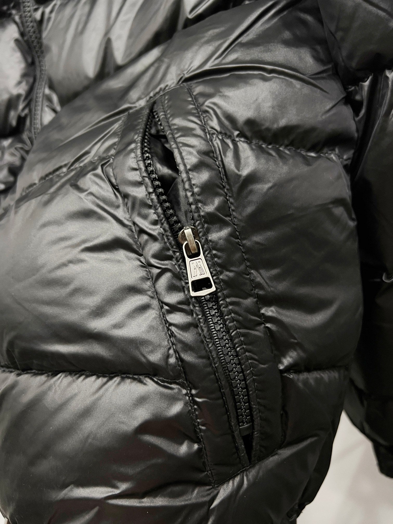 Moncler puffer jacket close-up, dark black front zipper and quilted stitching