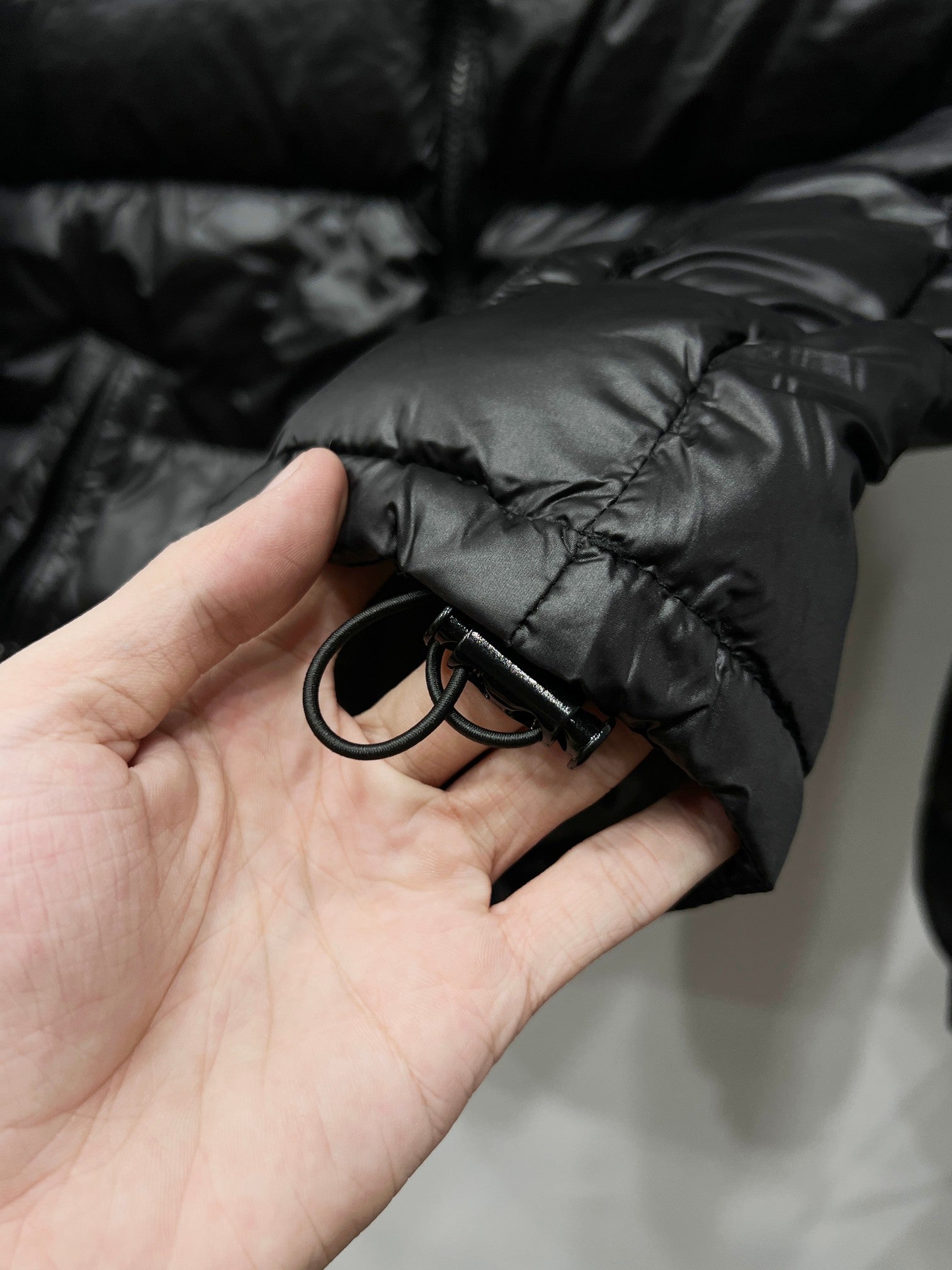 Moncler puffer jacket sleeve cuff detail, dark black with drawstring cord