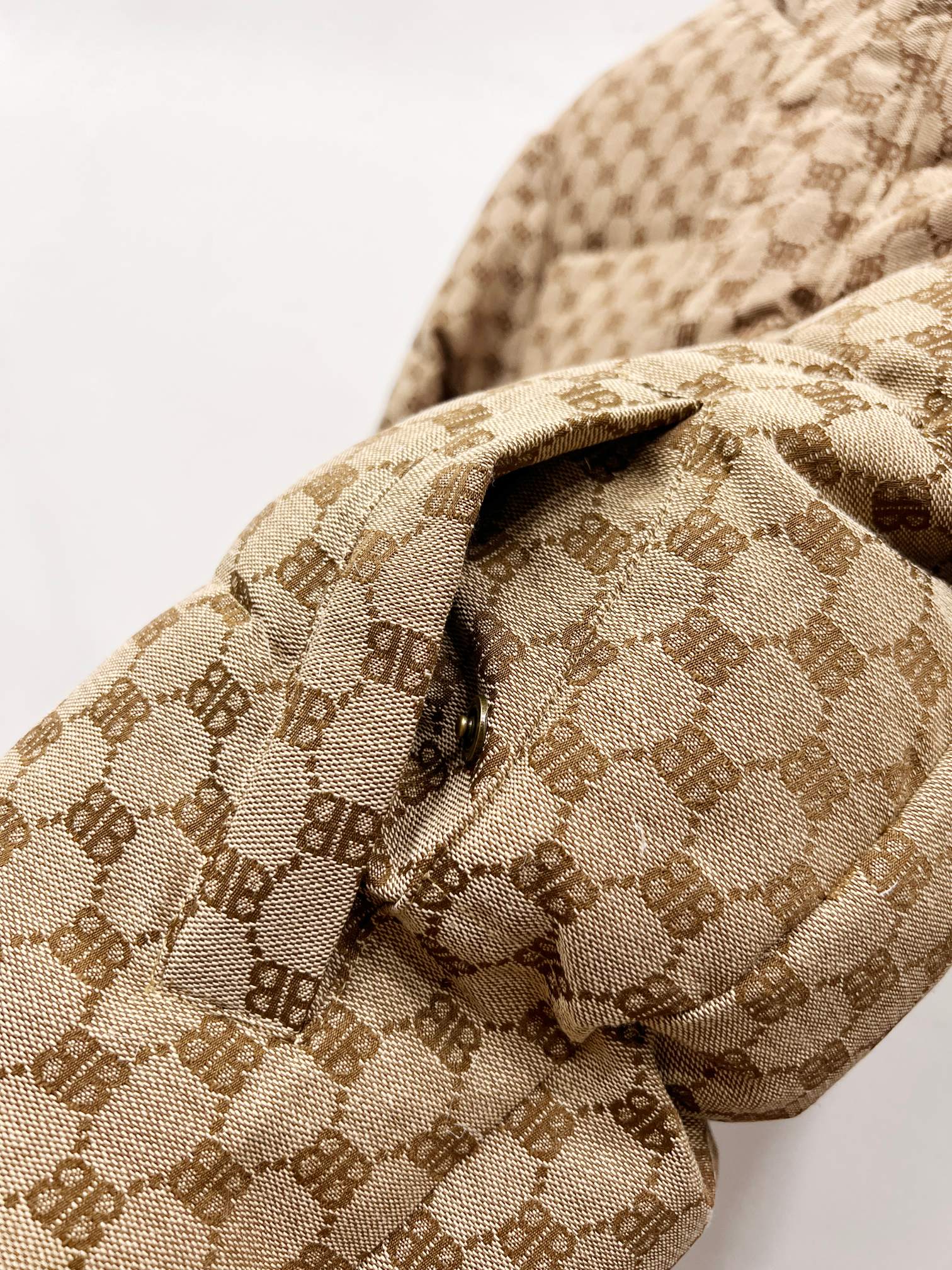 Gucci puffer jacket sleeve detail in beige monogram fabric with quilted patch panel