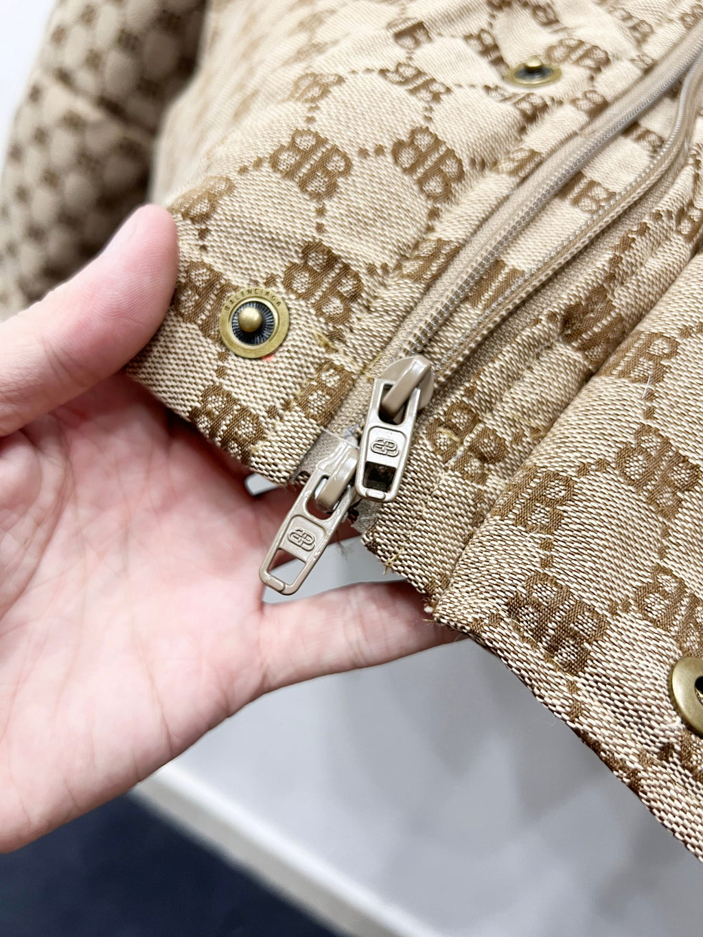 Gucci puffer jacket cuff detail: beige monogram fabric with snap buttons and zipper