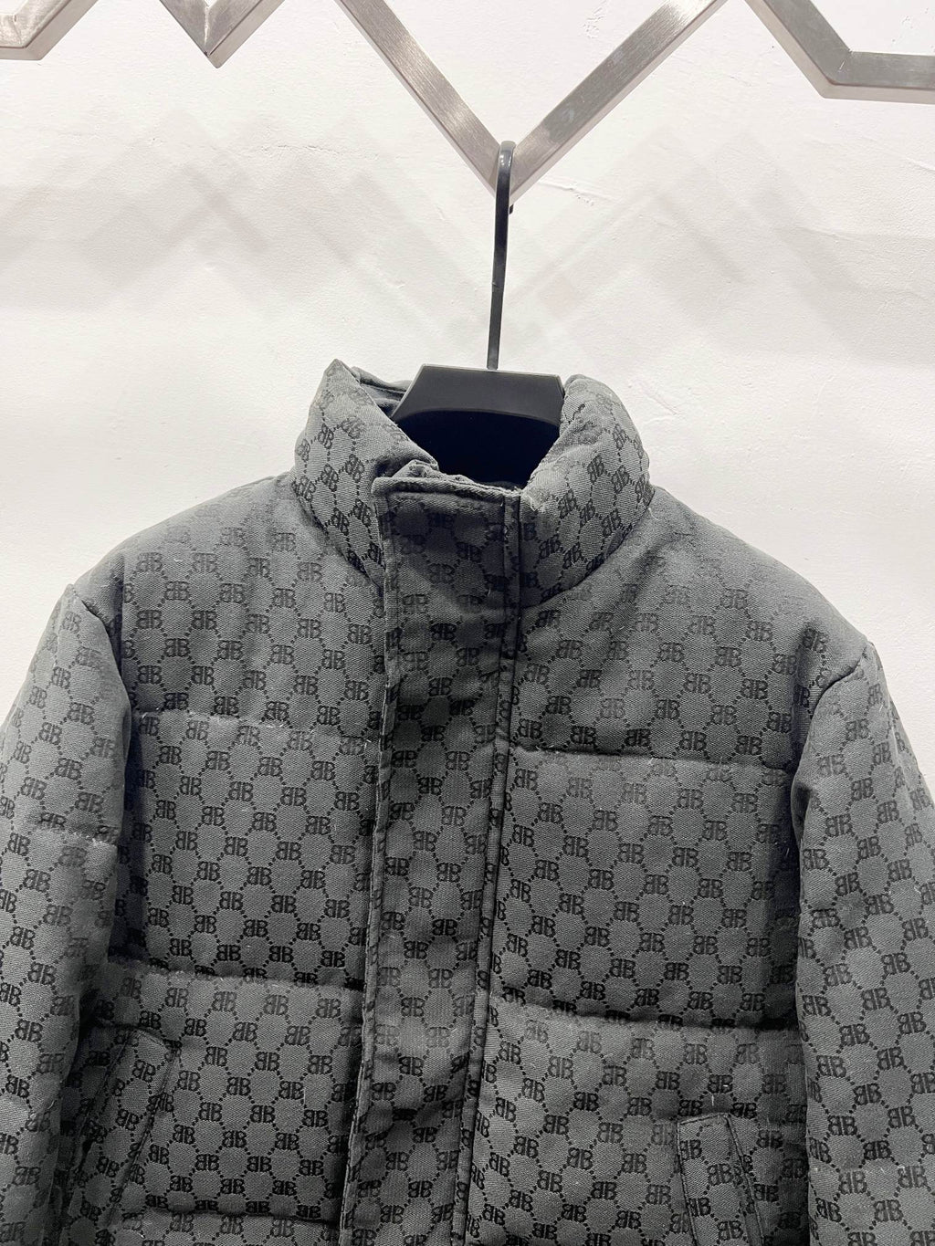 Dark gray long puffer jacket front close-up with zip and quilted monogram stand collar