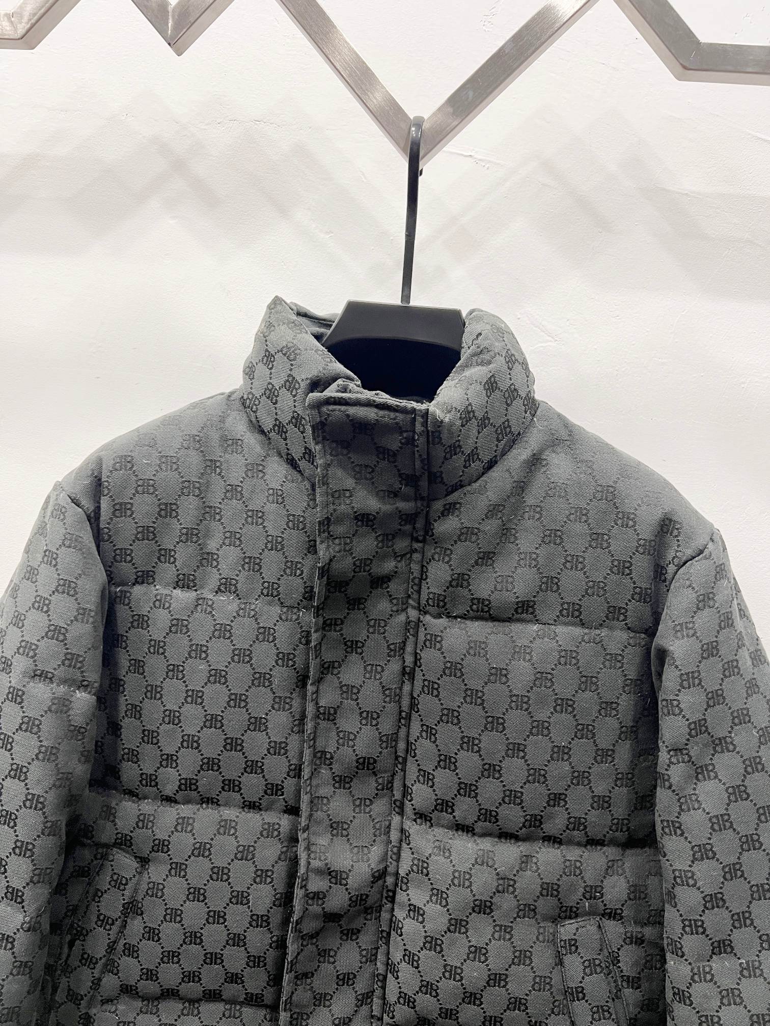Dark gray long puffer jacket front close-up with zip and quilted monogram stand collar