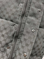 Dark gray puffer jacket front with metal zipper and snap buttons on placket