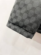 Dark gray puffer jacket hem with quilted monogram pattern and stitched edge