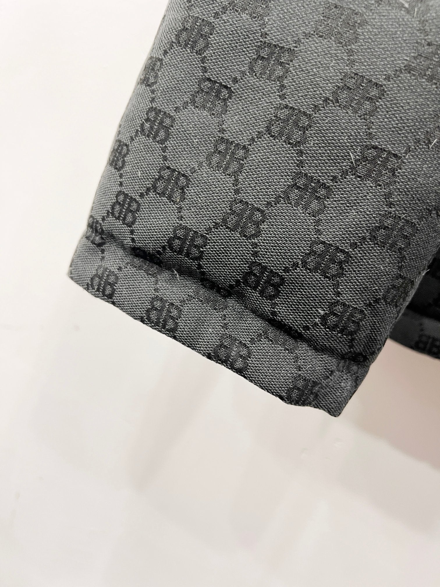 Dark gray puffer jacket hem with quilted monogram pattern and stitched edge