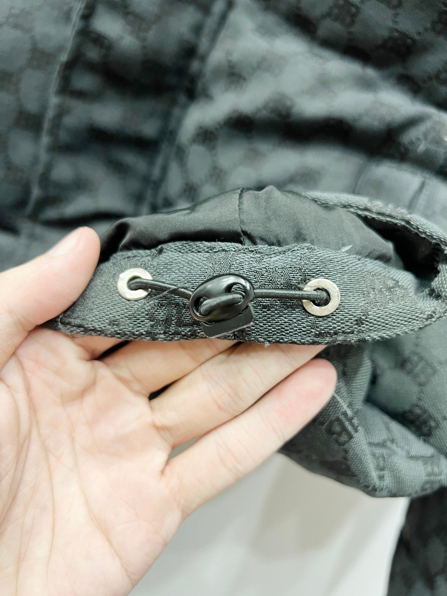 Dark gray puffer jacket with adjustable drawcord hem and metal eyelets