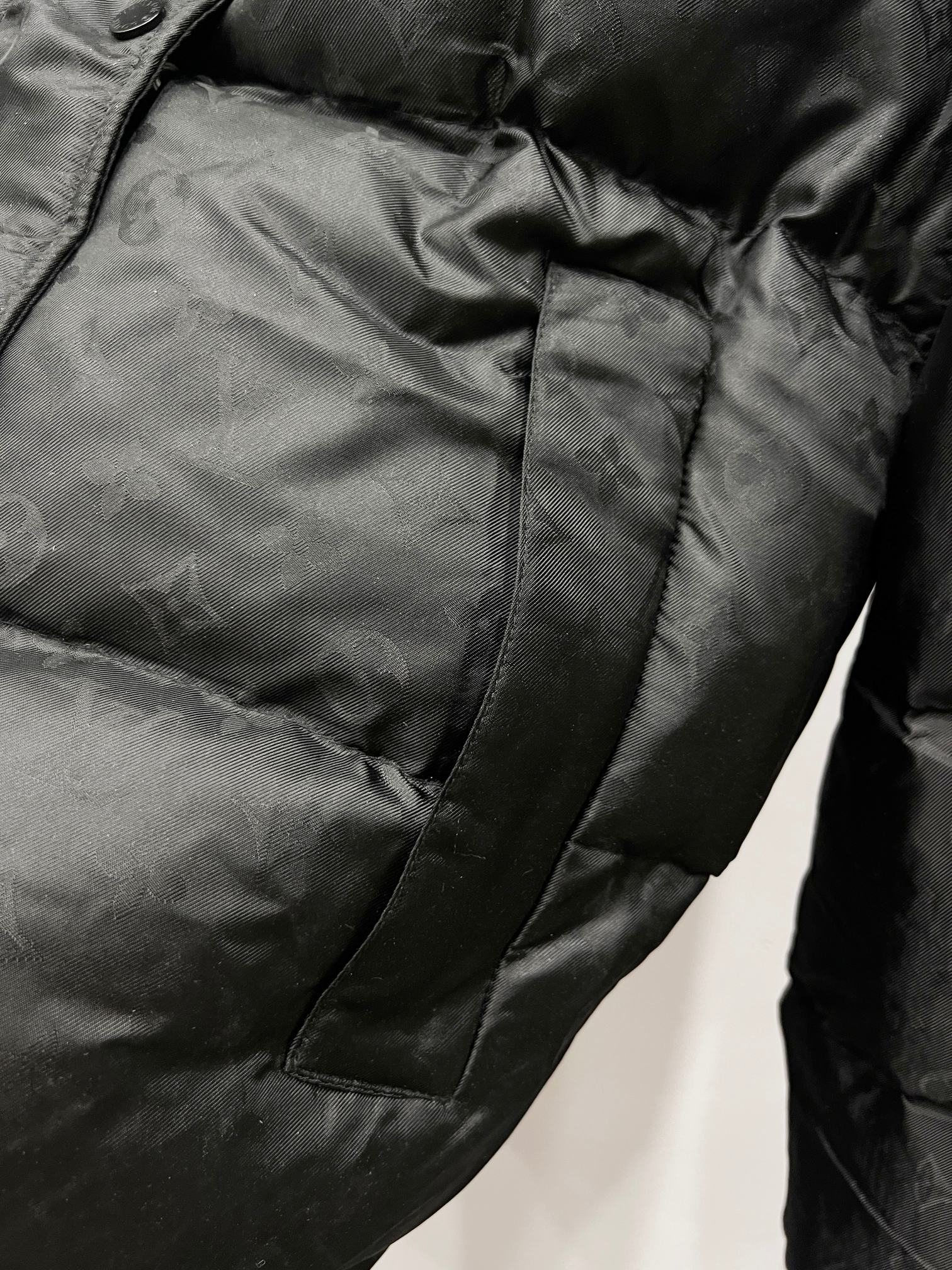 Black puffer jacket with quilted panels and stitched pocket detail
