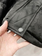 Black hooded puffer jacket cuff with snap and circular logo patch