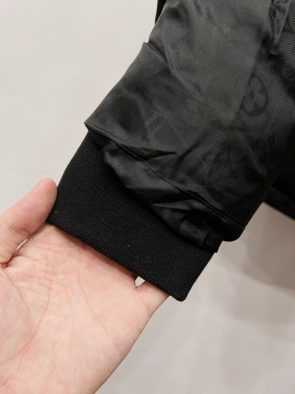 Black puffer jacket hem with folded cuff and elastic cinch