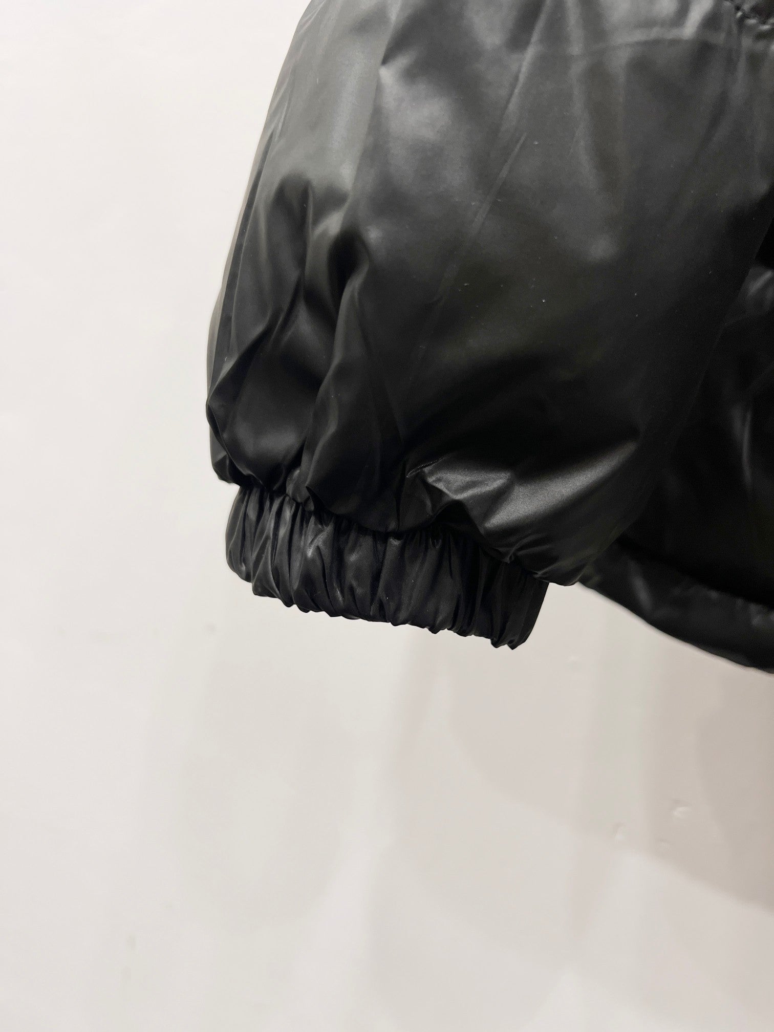 Moncler long puffer jacket sleeve with elastic cuff and quilted dark fabric