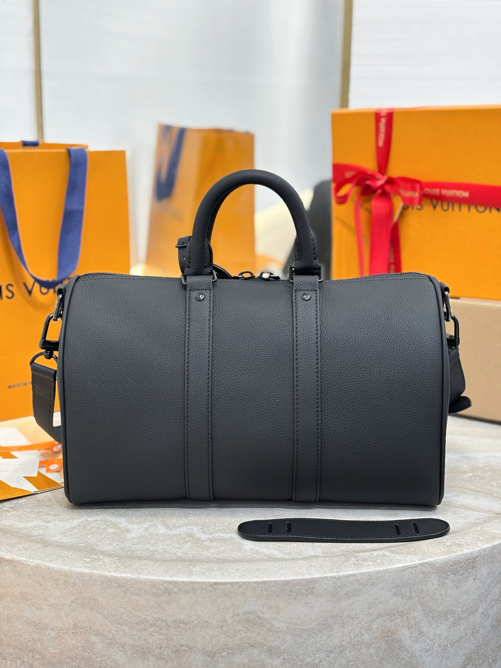 Louis Vuitton leather bag with dual top handles and crossbody strap, dark gray.