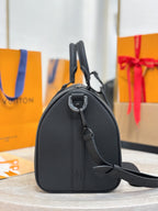Louis Vuitton rounded leather bag with top handle and shoulder strap, dark gray.