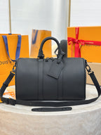 Louis Vuitton leather handbag with top handles and shoulder strap, dark gray.