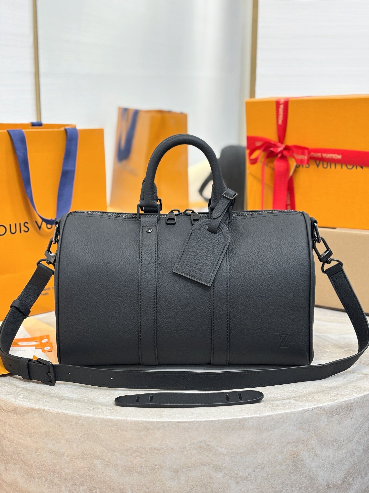 Louis Vuitton leather handbag with top handles and shoulder strap, dark gray.