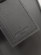 Louis Vuitton leather tag and stitched pocket close-up, dark gray.