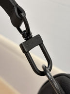 Louis Vuitton leather strap close-up with metal clip hardware, dark gray.