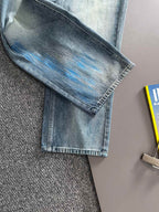 Folded light blue denim jeans with washed blue pattern on the knee area, straight leg