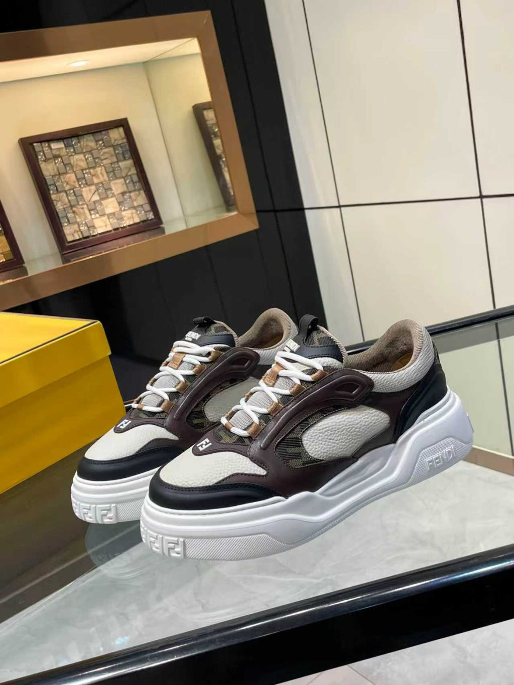 Two Fendi unisex chunky sneakers on display, brown and black uppers with white platform