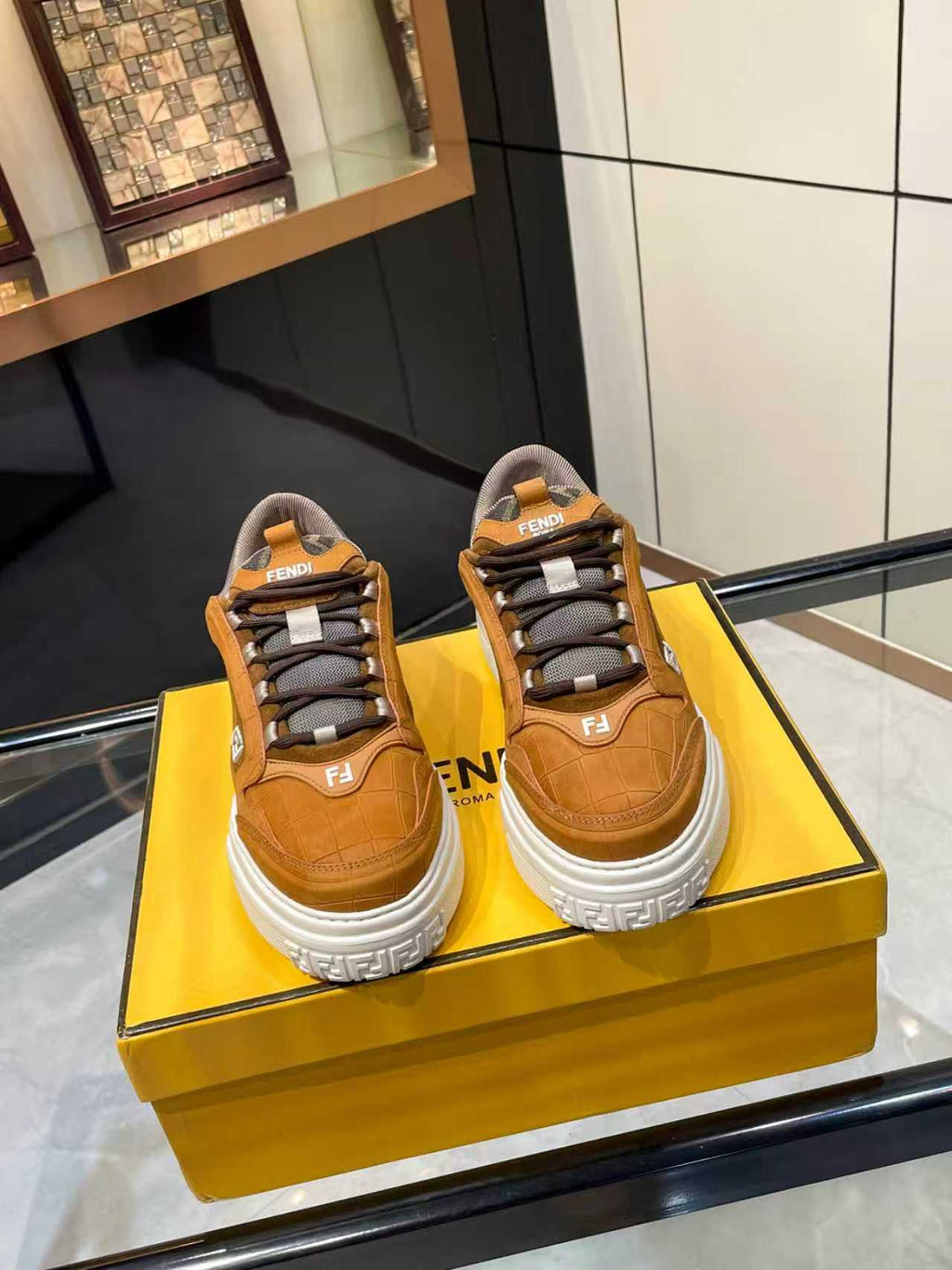 Brown Fendi unisex sneakers with lace-up straps and chunky white sole, side view.