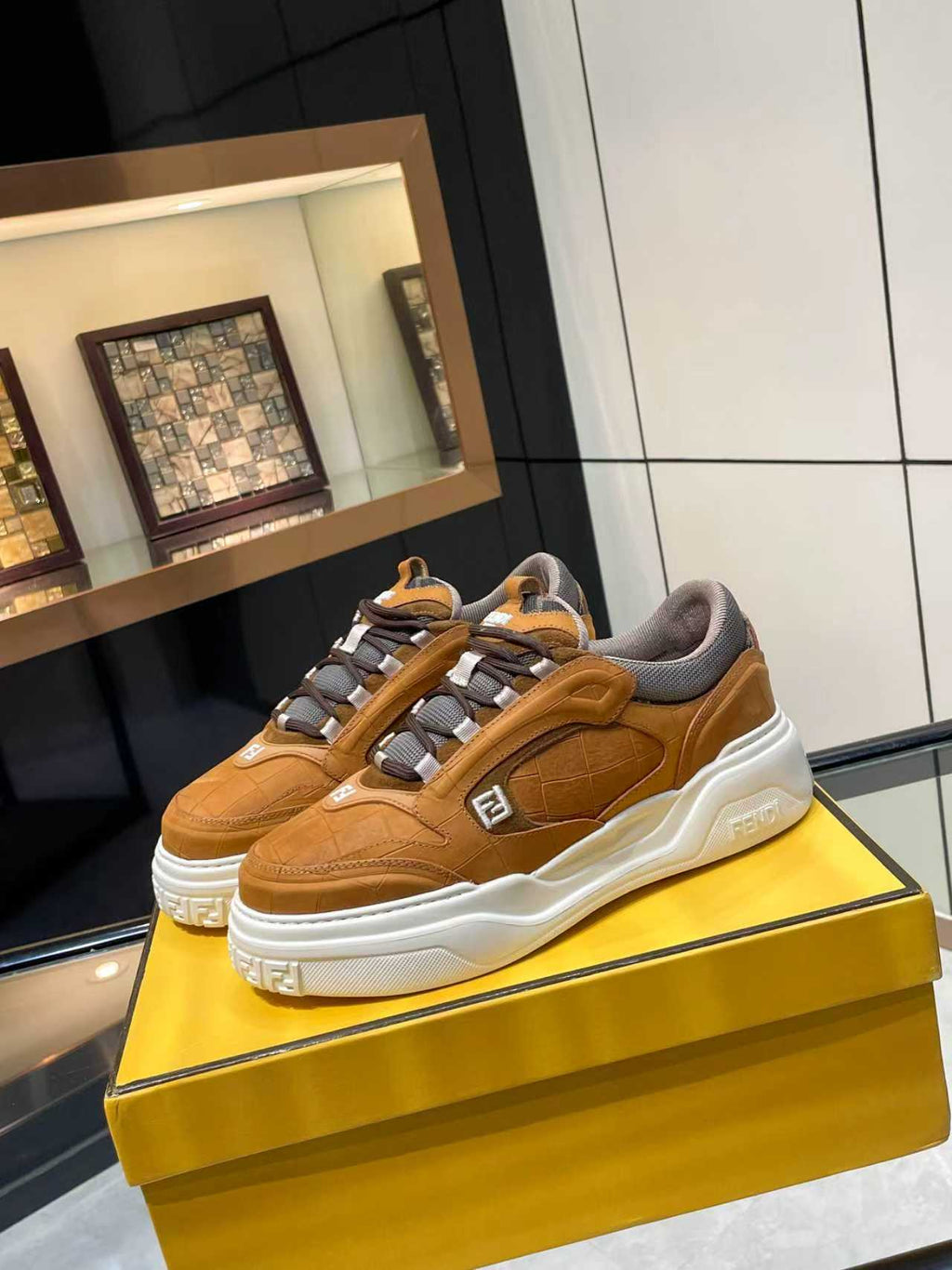 Tan-brown Fendi sneakers pair on display with lace-up straps and chunky white sole.
