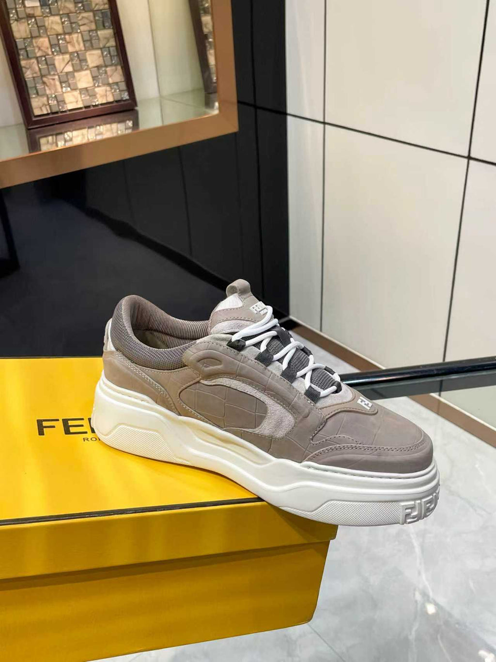 Taupe Fendi lace-up sneakers with thick white sole and side logo patch, side/front view
