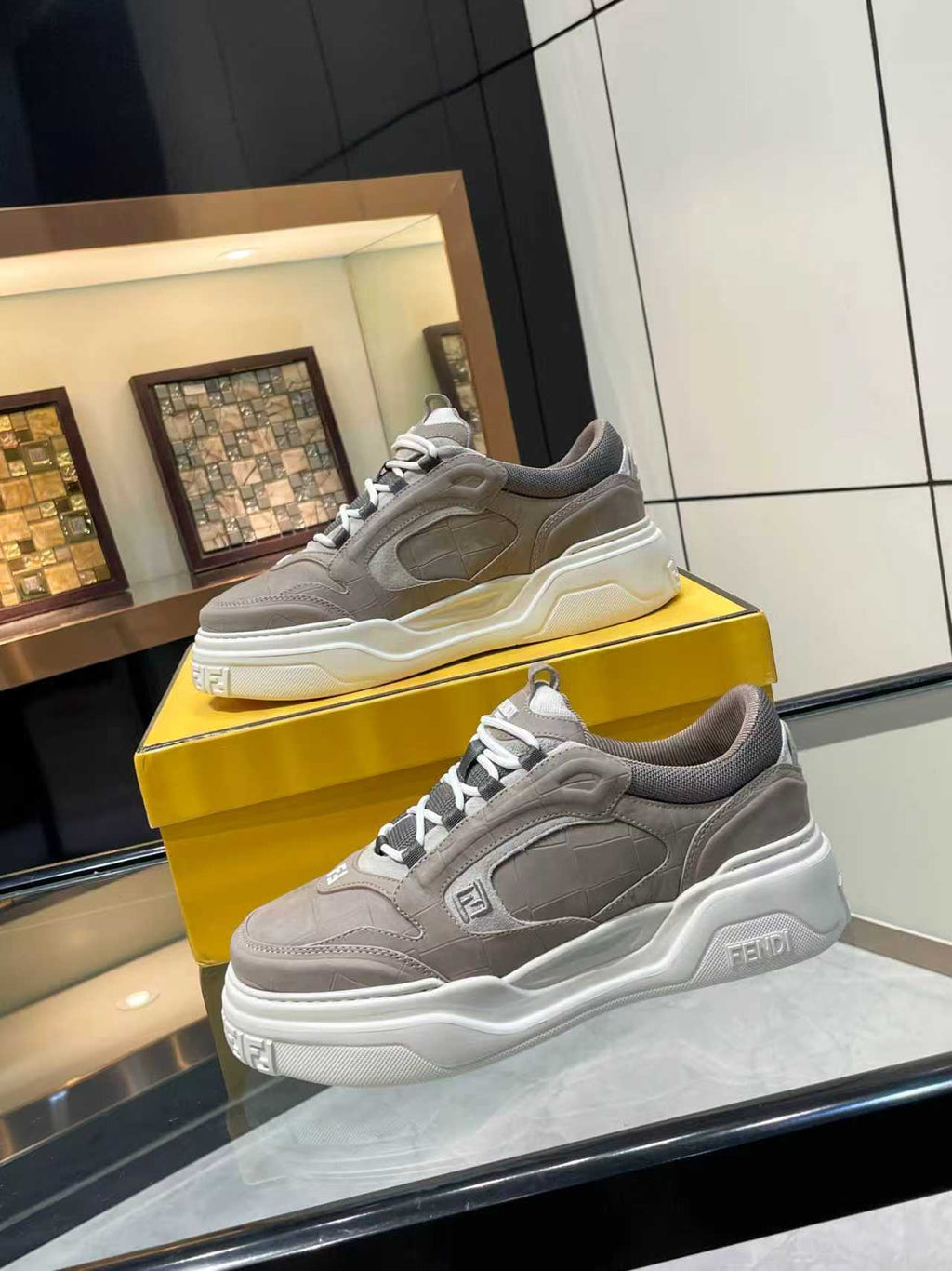 Gray Fendi chunky lace-up sneakers with white sole, lace eyelets, and side logo