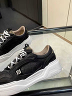 Close-up of black lace-up sneakers with white chunky sole and Fendi logo