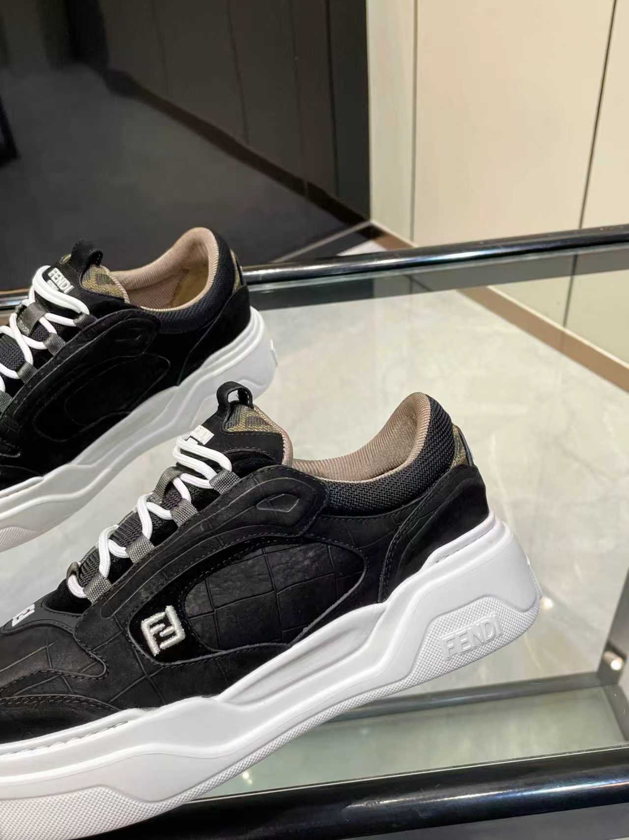 Close-up of black lace-up sneakers with white chunky sole and Fendi logo