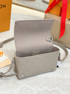 Light gray mini crossbody bag with monogram texture, open top, silver chain strap