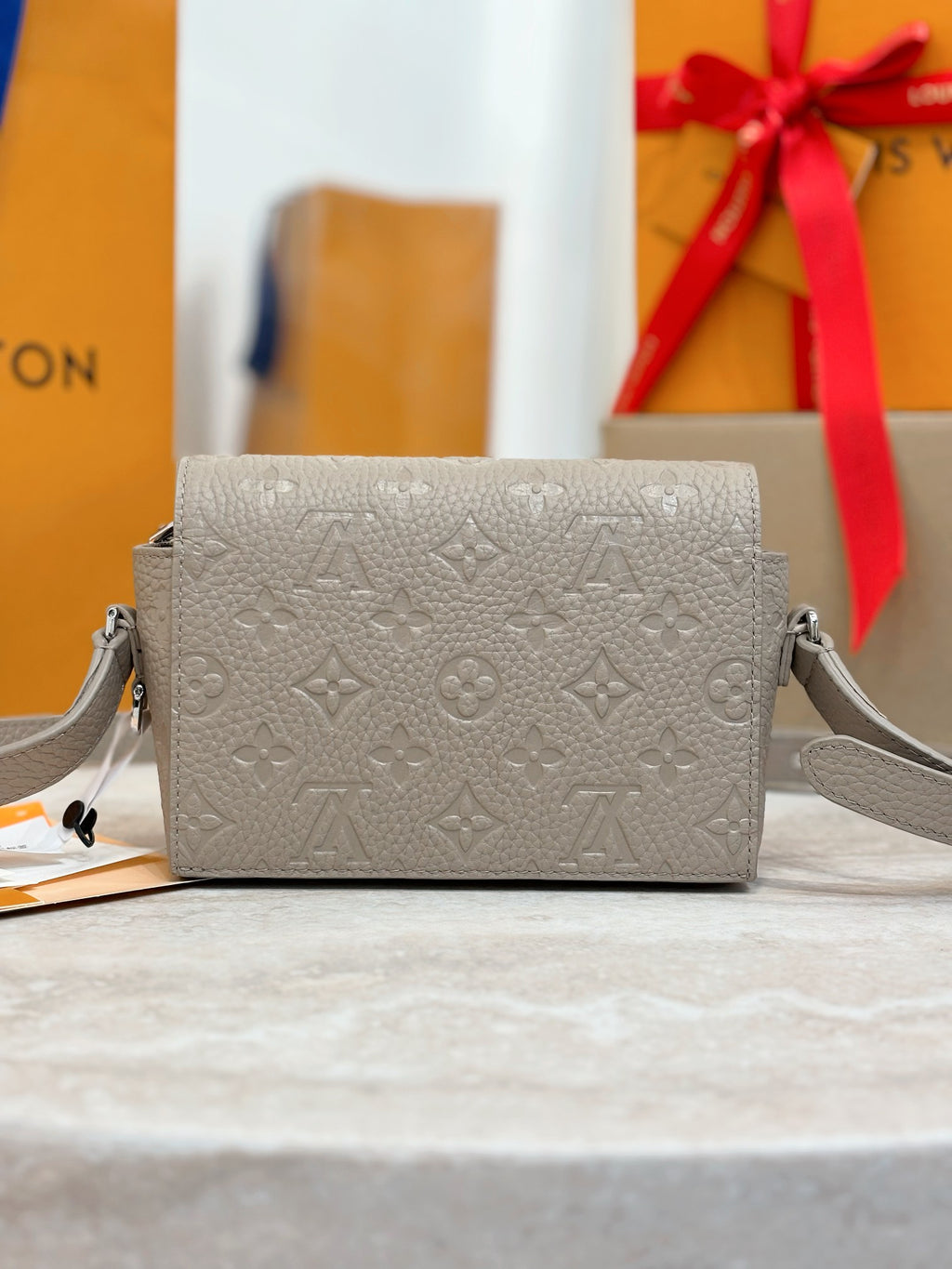 Crossbody bag in light gray with monogram embossing and silver chain strap