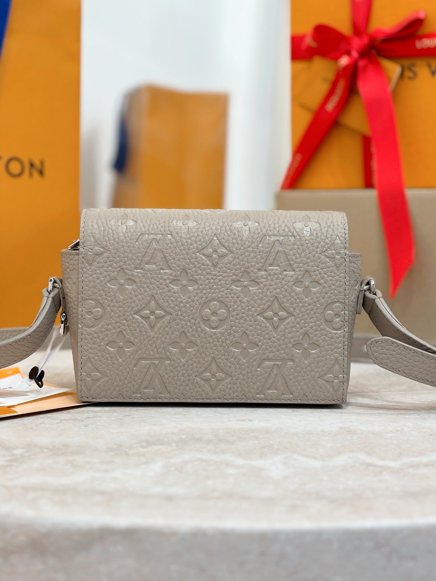 Crossbody bag in light gray with monogram embossing and silver chain strap