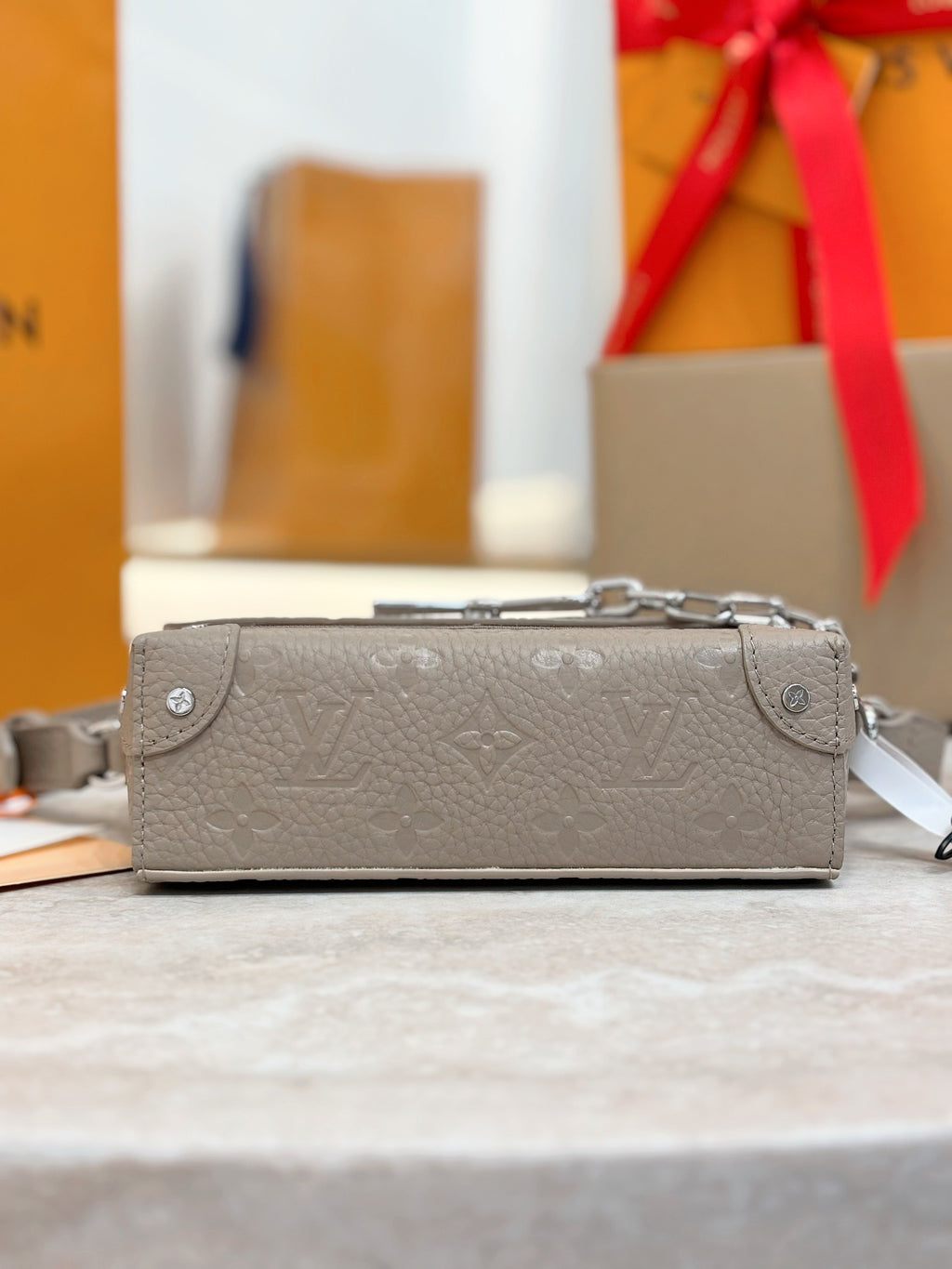Light gray crossbody bag with monogram embossing, silver hardware and chain strap