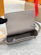 Light gray crossbody bag open view with monogram texture and silver zipper hardware