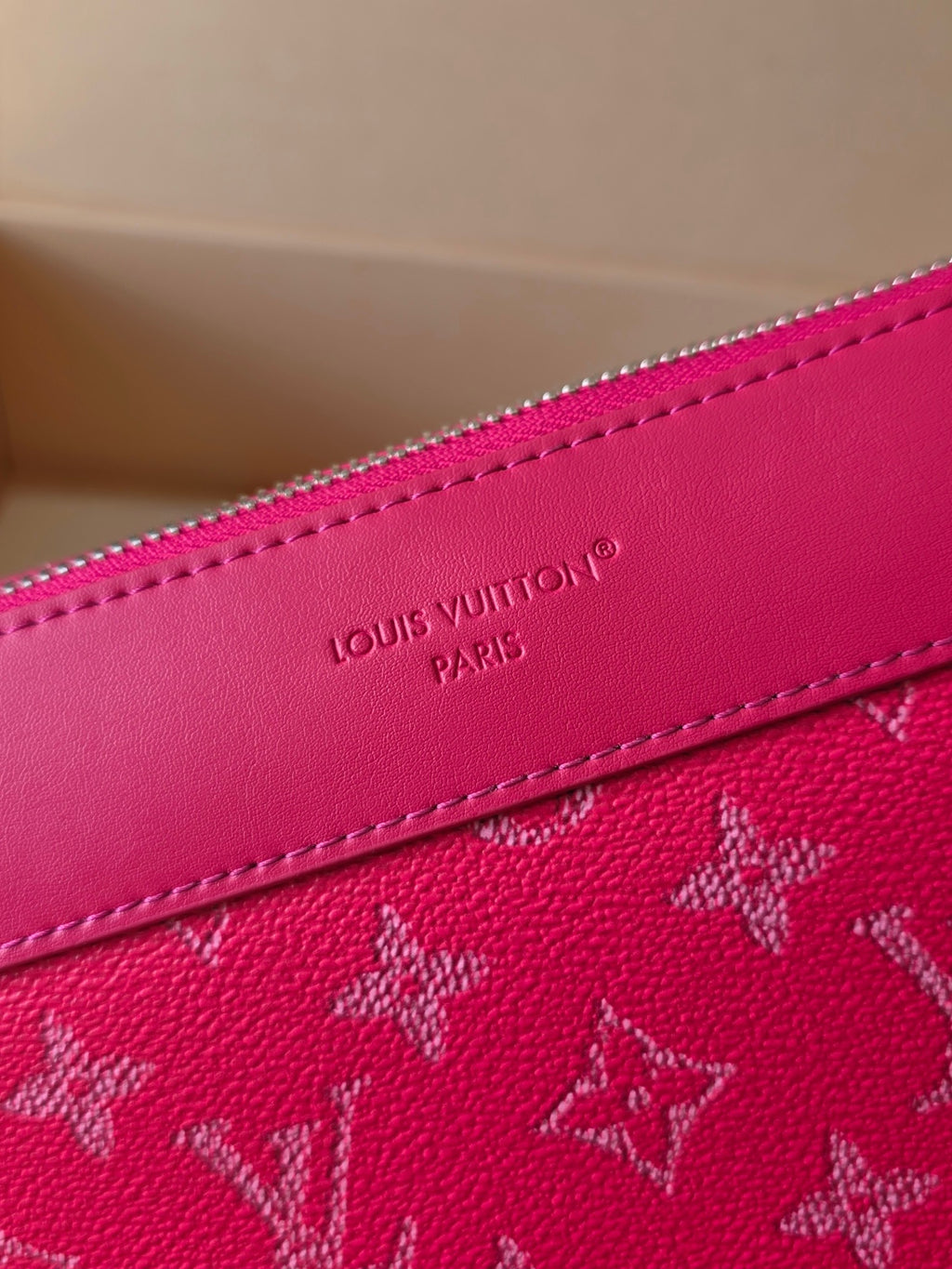 Louis Vuitton pink bag close-up of embossed trim and stitching near zipper