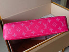 Pink Louis Vuitton small bag laid flat, showing white monogram pattern across the front.