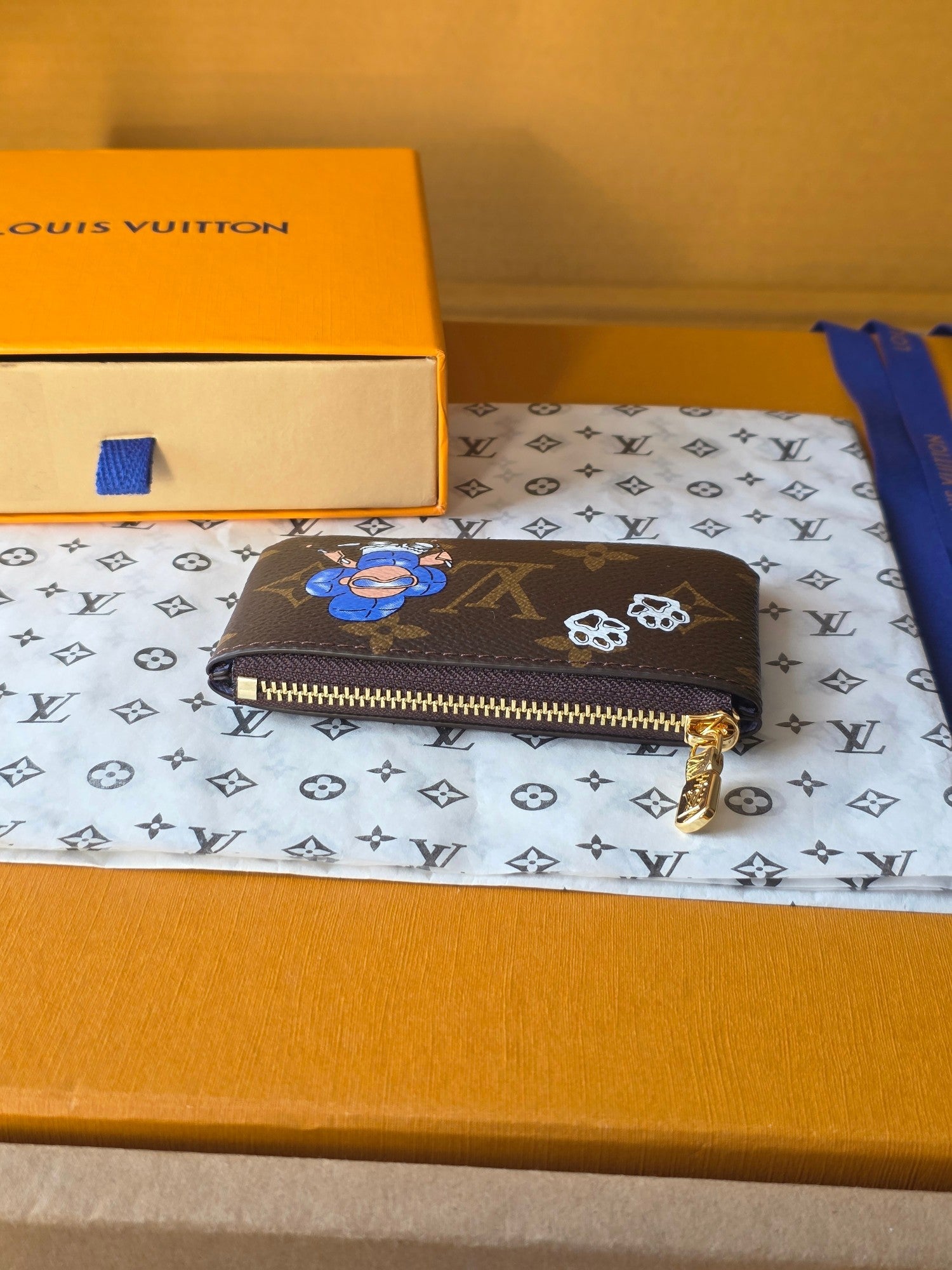 Louis Vuitton small bag side view with gold-tone zipper and monogram leather.