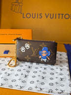 Louis Vuitton small bag with zip top, monogram print and blue character artwork.