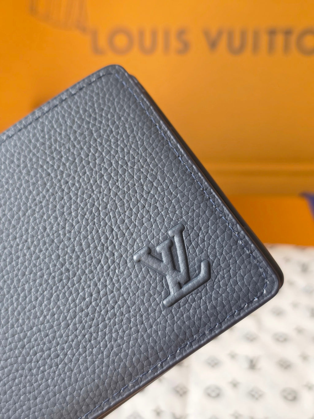 Small bag: Louis Vuitton blue leather card wallet close-up of embossed logo
