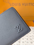 Small bag: Louis Vuitton blue leather card wallet close-up of embossed logo