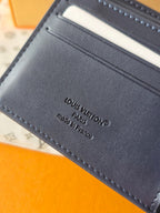 Small bag: Louis Vuitton blue leather card wallet close-up of stamped brand text