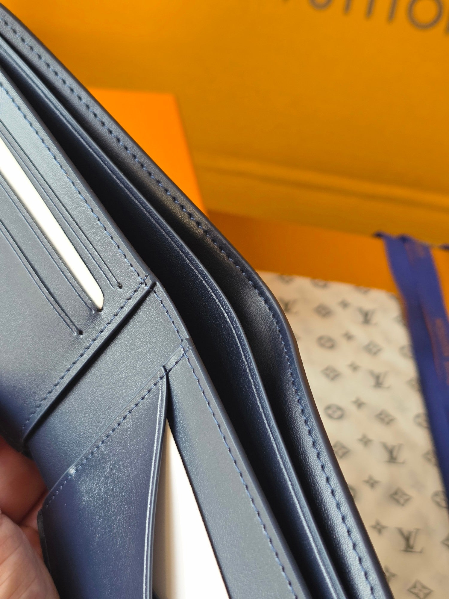 Small bag with light blue leather handle edge and visible stitching