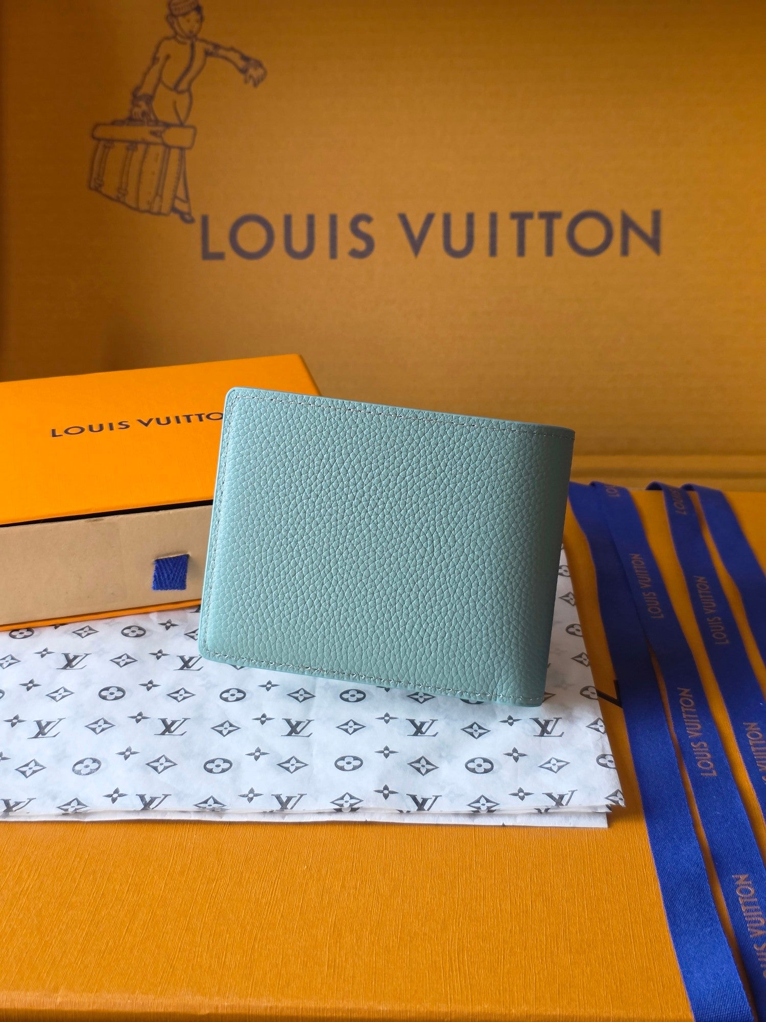 Light blue small bag wallet with Louis Vuitton monogram on front panel