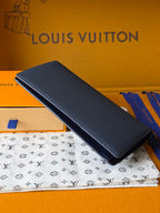 Small leather wallet with dark blue pebbled exterior and slim foldover profile