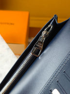 Small leather wallet close-up of zipper pull, metal rings, and stitched edge