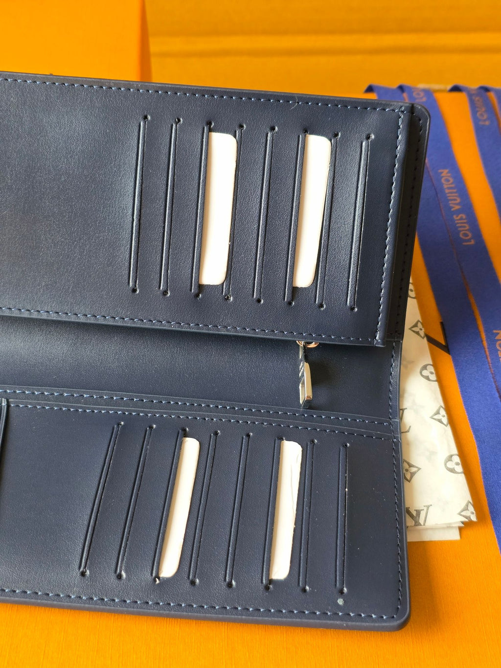 Small leather wallet interior showing card slots with gold-tone bars on panels