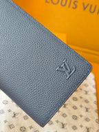 Small leather wallet corner detail with embossed LV logo and pebbled texture