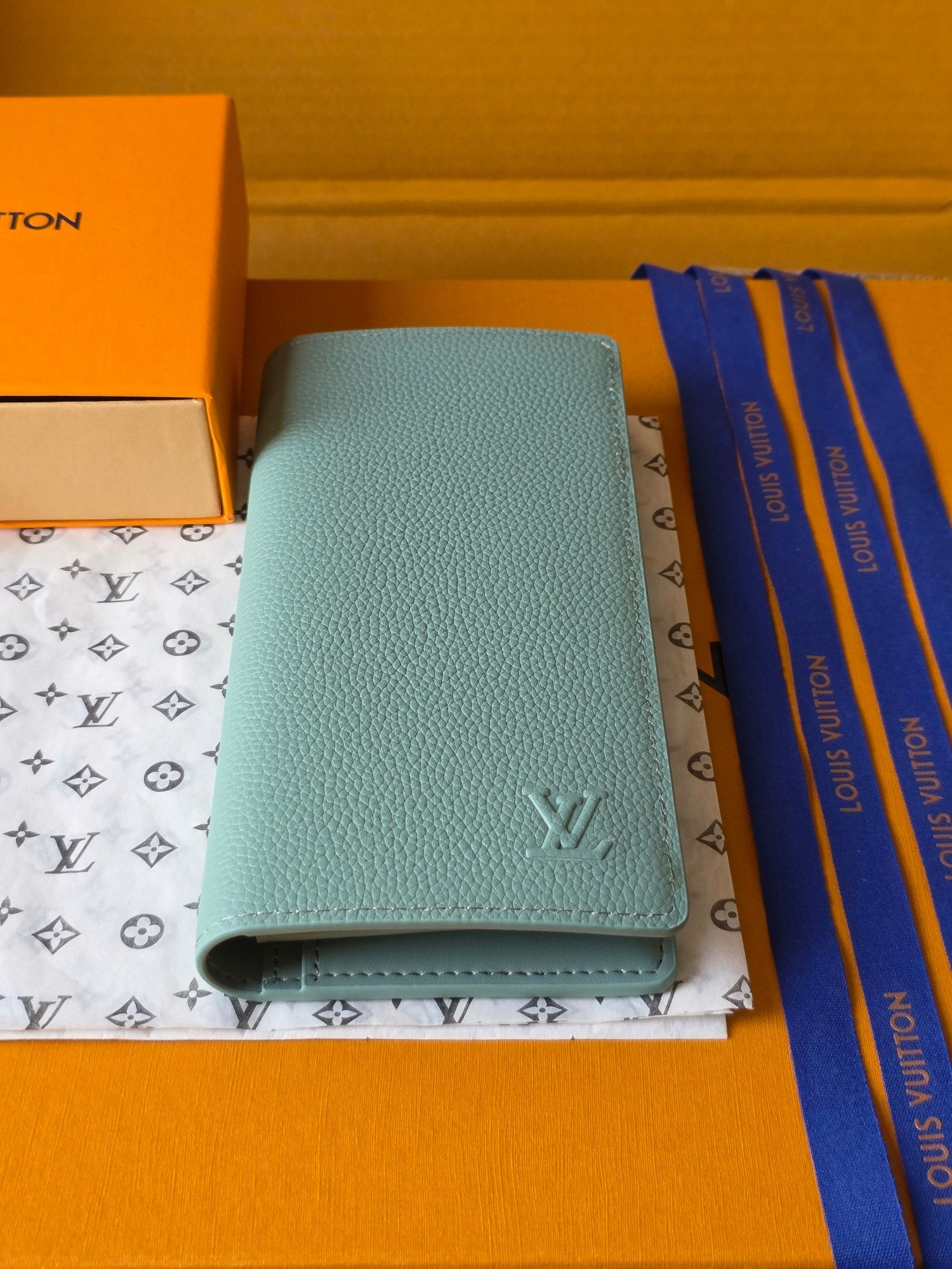 Light blue leather small bag with Louis Vuitton emblem and snap closure