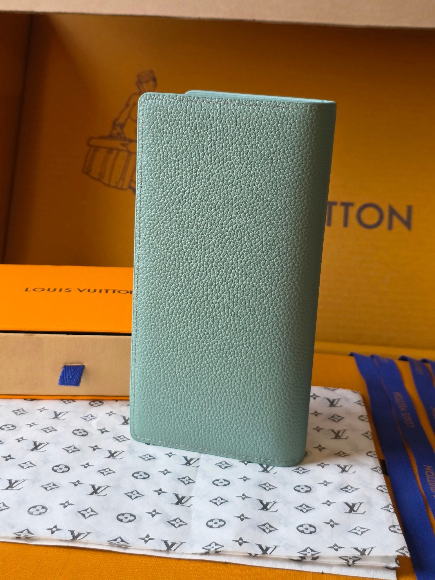 Light blue leather small bag upright view with Louis Vuitton logo on front