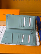 Light blue leather small bag open with pen or card slots and snap pockets
